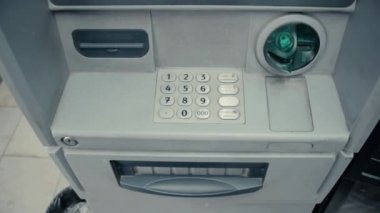 Yeşil gri Atm para çekme makinesi yuvaya yanıp sönüyor. ATM makine yanıp sönen ve kredi kartı kabul etmeye hazır. Basamak ile metal tuş takımı. Yeşil plastik eklemek. Hacker koruma. Üstten üstten görünüm