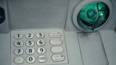 Yeşil gri Atm para çekme makinesi yuvaya yanıp sönüyor. ATM makine yanıp sönen ve kredi kartı kabul etmeye hazır. Basamaklı pin için metal tuş takımı girin. Yeşil plastik eklemek. Muhafaza--dan kesmek.