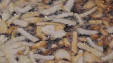 Sebze ayçiçek yağı bir tavada sıcak siyah font bir gaz kaynar suda kavurma kıyılmış beyaz soğan karamelize dilim Close-Up soba. Geleneksel doğal baharatlı meze