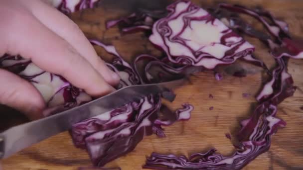 赤キャベツのスライスは 木製キッチン テーブルの上鋼ナイフでカットです カット スライス上で美しいパターン 健康食品 野菜のダイエット 菜食主義 — ストック動画