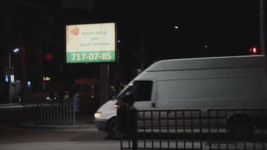 Dnipro, Ukrayna - 11 Şubat 2019: Işıklı billboard. Reklam ajansı aydınlık silindir ekranda hizmetlerini tanıtır. Akşam Sokağı. Yaya geçidi. İnsanlar karşıdan karşıya. Trafik ışığı