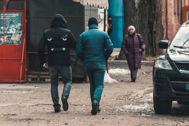 İki adam sokakta yürürken. Buldog yüz tasarım üzerinde ceket geri. Bir genç kızın görüntü ile Coca-Cola reklam afişi. Hafif bir palto yaşlı bir kadın