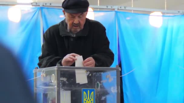 An elderly male voter puts the electoral ballot in ballot box — Stock Video