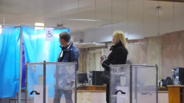 Jonge mannelijke kiezer zet het stembiljet in de stembus — Stockvideo