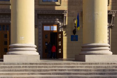 Dnipro, Ukrayna - 31 Mart 2019: Yoklama İstasyonu Üniversitesi binada yer girişi. Ukrayna Cumhurbaşkanı seçim. Kapının yanında uçan Ukrayna bayrağı