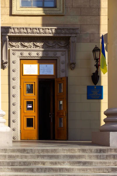 DNIPRO, UKRAINE - March 31, 2019: Entrance to the place of the polling station in the university building. Election of the President of Ukraine. Ukrainian flag flying near the door — Stock Photo, Image