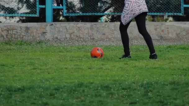 Onherkenbaar meisje trapt de bal in het stadion. Jonge vrouw — Stockvideo