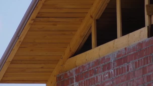 La maison est en construction contre le ciel bleu. Rouge brique — Video