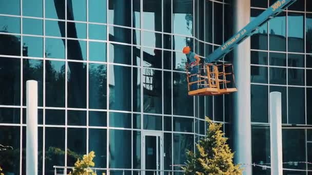 Pulitore di vetro uomo di lavoro su una finestra di pulizia ascensore idraulico — Video Stock