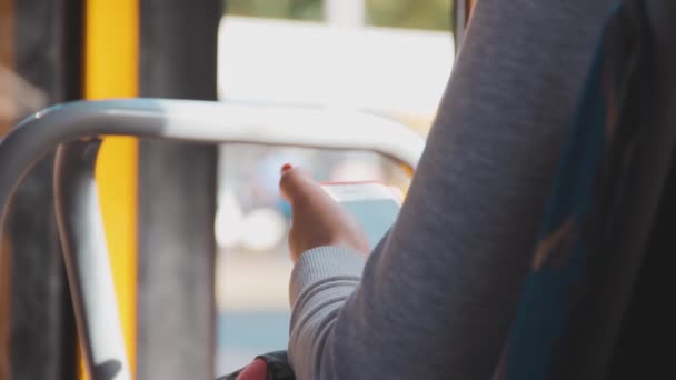 Vrouw in een licht gebreide blouse houdt een mobiele telefoon in haar handen — Stockvideo