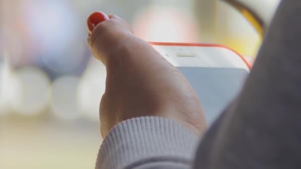 Eine Frau blickt auf den Bildschirm eines Gadgets. sonniger Sommertag. Öffentlicher Nahverkehr — Stockvideo