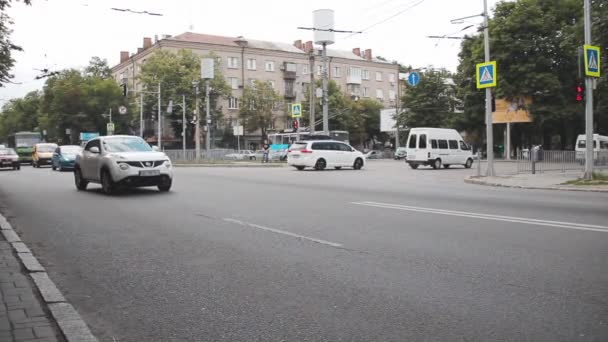Autos brausen die Straße entlang. Kreuzung in der Nähe einer Haltestelle für öffentliche Verkehrsmittel — Stockvideo