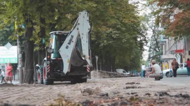 Kovalı kazıcı kaldırımda duruyor. İnşaat işi. Hazırlık