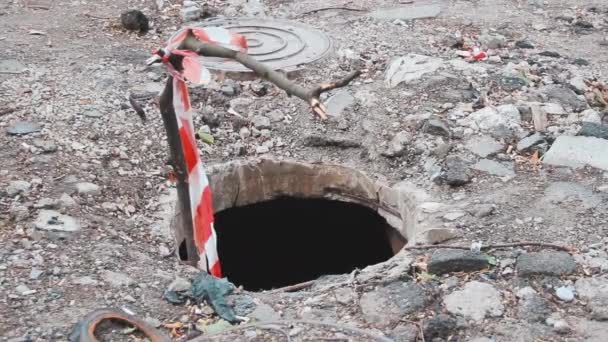 Varning röd-vit tejp stängsel över den öppna brunnen brunn brunn brunn brunn manhål. Problematiken — Stockvideo