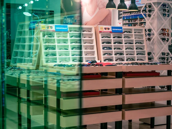 Moscow, Russia - September 14, 2019: Showcase with sunglasses in the optics salon. Glass in the foreground. Shop in the mall — Stock Photo, Image