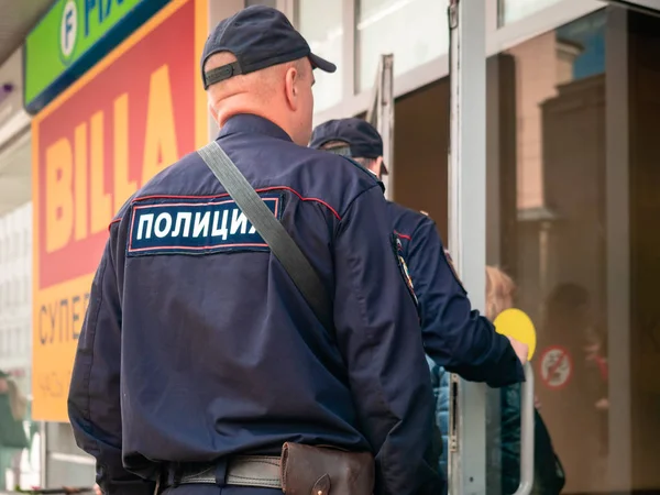 Moscú, Rusia - 14 de septiembre de 2019: Policías armados ingresan a un centro comercial. Dos hombres en uniforme de policía abren la puerta de una tienda de vidrio . — Foto de Stock