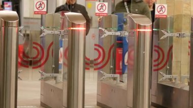 İnsanlar metro turnikelerinden geçiyor. Yolcular metroya girsin..