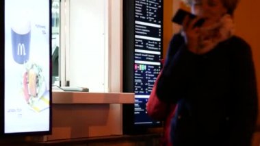 Fast food restoranı McDonald 's' ın siparişlerini vermek için pencere kenarındaki insanlar.