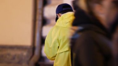 Sarı markalı sırt çantalı Yandex-eda servisi kuryesi caddede duruyor.