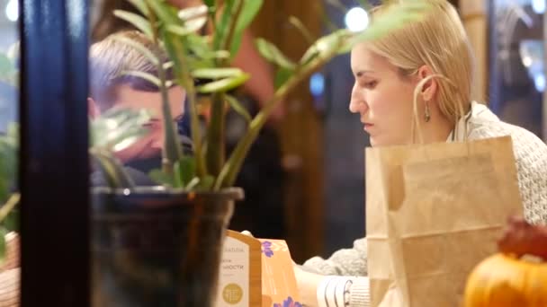 Un par de citas. Niño y niña están sentados en una mesa en un café de la calle y ta — Vídeos de Stock