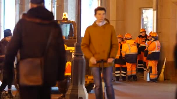 Grupo de trabajadoras del camino en uniforme naranja corporativo en la ciudad nocturna — Vídeos de Stock