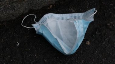 Atılmış koruyucu tek kullanımlık maske. Kullanılmış mavi tıbbi cerrahi maske