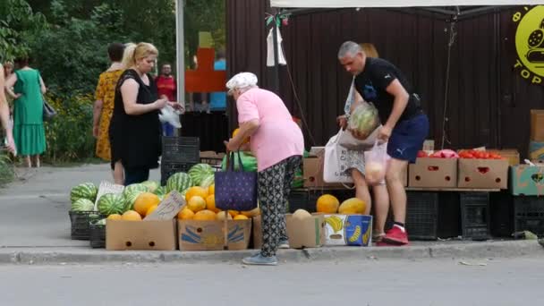 在炎热的夏日里，买瓜子和西瓜的人。人们选择蔬菜 — 图库视频影像