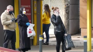 İnsanlar sosyal mesafeyi gözlemler ve toplu taşıma durağında dururlar. Sıcak güneşli