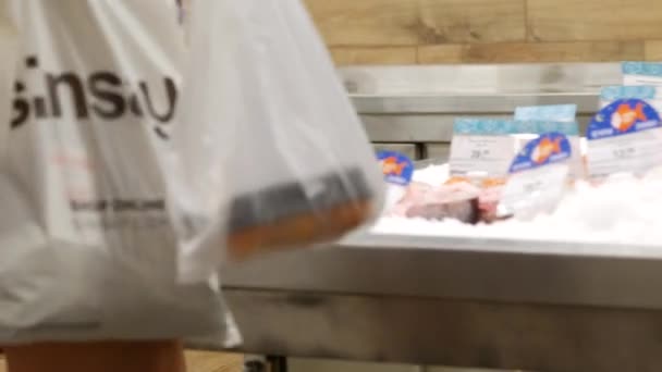 수퍼 마켓에 있는 예쁜 아가씨가 밥을 가리키고 있네. 연어의 무게가 나는 연어 — 비디오