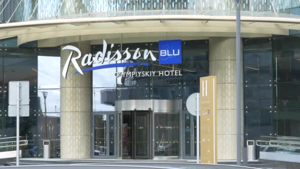 Radisson Blu Olympiyskiy Hotel. Hotelingang met draaideuren door een toegangspoort — Stockvideo
