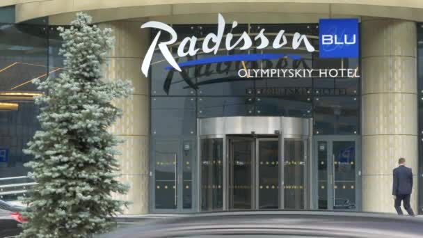 Radisson Blu Olympiyskiy Hotel. Вход в отель с вращающимися дверьми у ворот — стоковое видео