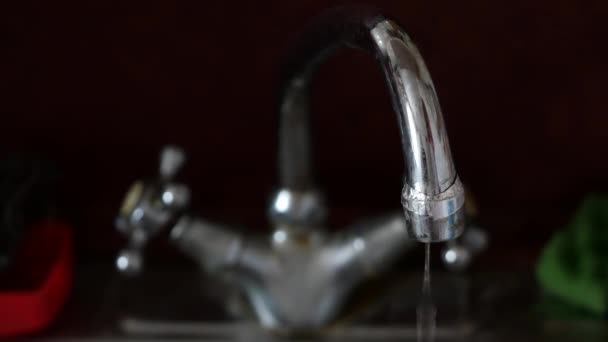 L'eau coule du robinet défectueux dans la cuisine. Vieux robinet de cuisine et évier dans la cuisine. — Video