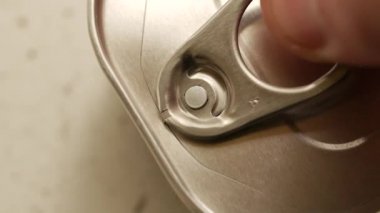 Morina ciğeri açıyorum. İnsan eli metalik teneke kapağı konserve yağlı balıkla açar.