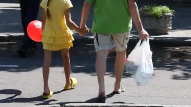 Child walks with daddy and pulls red balloon. Promoters give gifts to all buyers — Stock Video