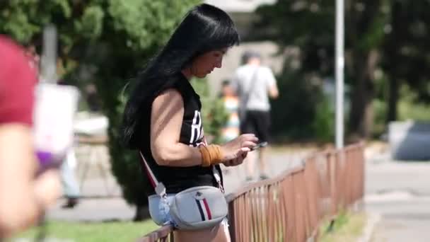Girl is waiting on street with phone. Pretty lady with french flag handbag — Stock Video