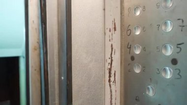 Metal asansör kapıları otomatik olarak açılır. Asansörün içi çok kötü yıpranmış.