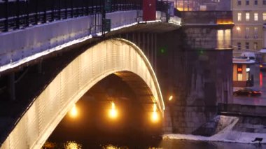 Şiddetli kar yağışı sonrası akşam şehri. Büyük Krasnokholmsky Köprüsü. Arabalar gidiyor.