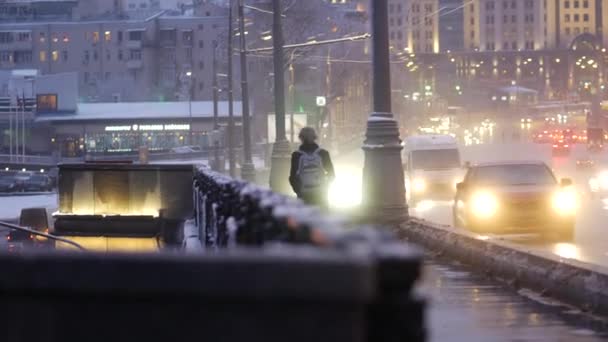 Kvällsstad Snö Efter Kraftigt Snöfall Killen Går Över Moskvaflodens Bro — Stockvideo