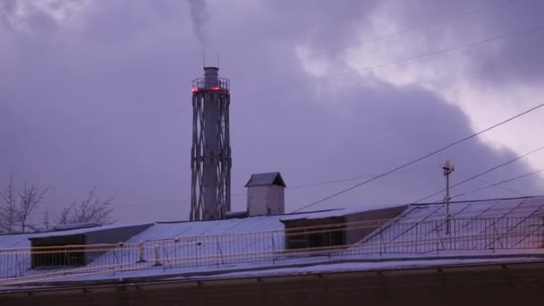 煙突から煙が立ち上がる 高い煙突と空に重い暗い蒸気雲と工業プラント 夕方の街の夕暮れ 寒い冬の日 二酸化炭素だ 雪の冬 都市生態学 スモッグ 夕方の霧 — ストック動画