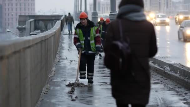 一名道路工人穿着制服，在降雪后用铲子铲雪 — 图库视频影像
