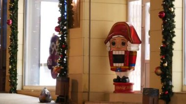 İnsanlar şehirde cadde boyunca yürürler. Fındıkkıran heykeli mağaza girişinde