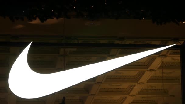 Sebuah logo besar bersinar Nike di jendela toko perusahaan di Kuznetsky Most — Stok Video