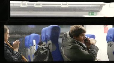 Kadın tren vagonunda cep telefonuyla konuşuyor. Moskova 'daki MCC trenindeki yolcu