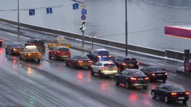 Yoğun bir kar yağışı sonrası akşam şehri. Kar taneleri yol kablolarında donar
