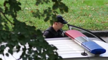Devriye polisi arabaya bin. Siyah üniformalı, kurşun geçirmez yelekli ve silahlı adamlar.