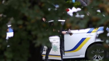 Polis memurları kelepçeli bir suçluyu polis arabasına bindirdi. Siyahlı adamlar