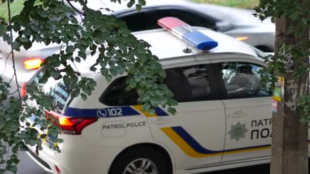 Αστυνομικός περιπολίας στο αυτοκίνητο στήνει ασύρματο. Λευκό περιπολικό με έμβλημα το σήμα — Αρχείο Βίντεο