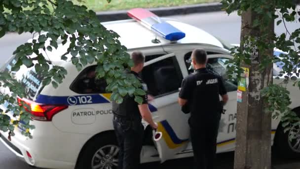 Policías de patrulla suban al auto. Hombres en uniforme negro con chalecos antibalas y pistola — Vídeo de stock