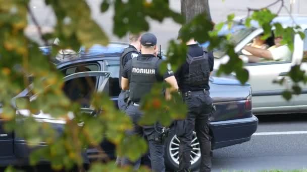 Polisen stoppade inkräktarnas bil. Män i svarta skottsäkra västar. Arresteringar — Stockvideo