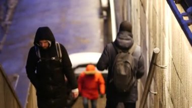 Yayalar gün batımında Moskva Nehri 'nin Büyük Krasnokholmsky Köprüsü' ne çıkan merdivenleri çıkıyorlar.